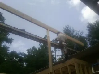 Carpenter setting a ridge beam over a new addition frame — Ice Dam Removal by Roofing Brothers in Berrien Springs