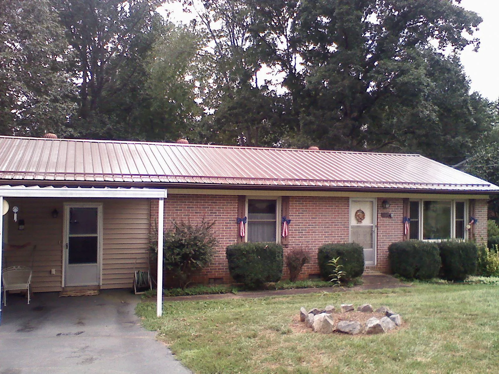 Bronze metal roof and carport on a brick ranch home — Roof Repair work by our crew in Berrien Springs
